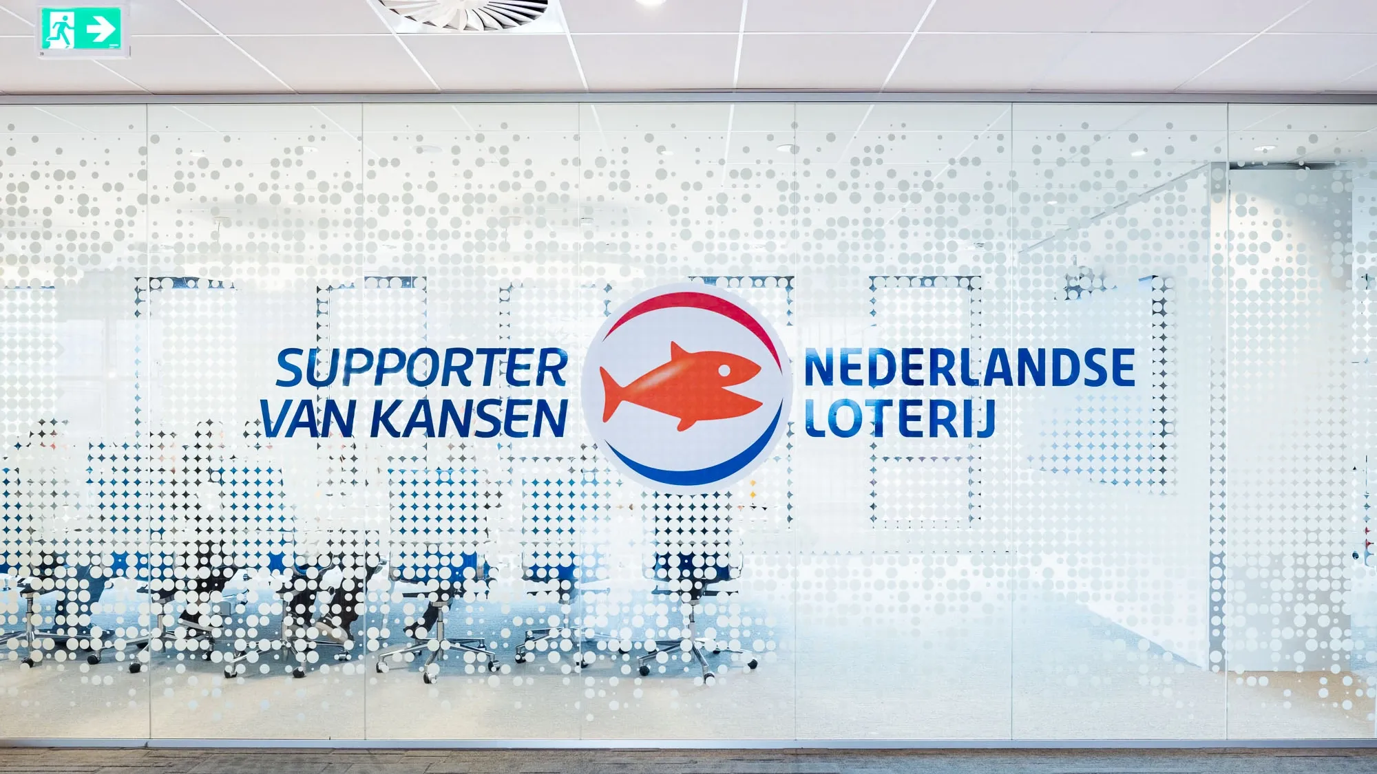 Glaswand met het logo van de Nederlandse Loterij en de tekst 'Supporter van Kansen'.