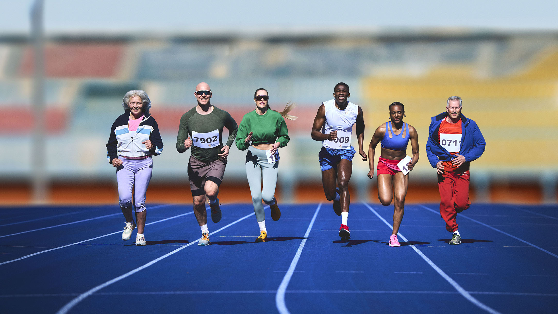 Sporters naast elkaar aan het rennen op atletiekbaan